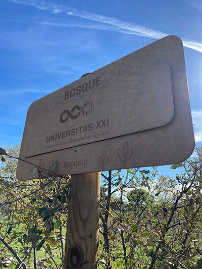 Foto de cartel de bosque reforestación con el logo de UNIVERSITAS XXI